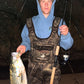 Angler with a striped bass and Inshore Reaper rod at night