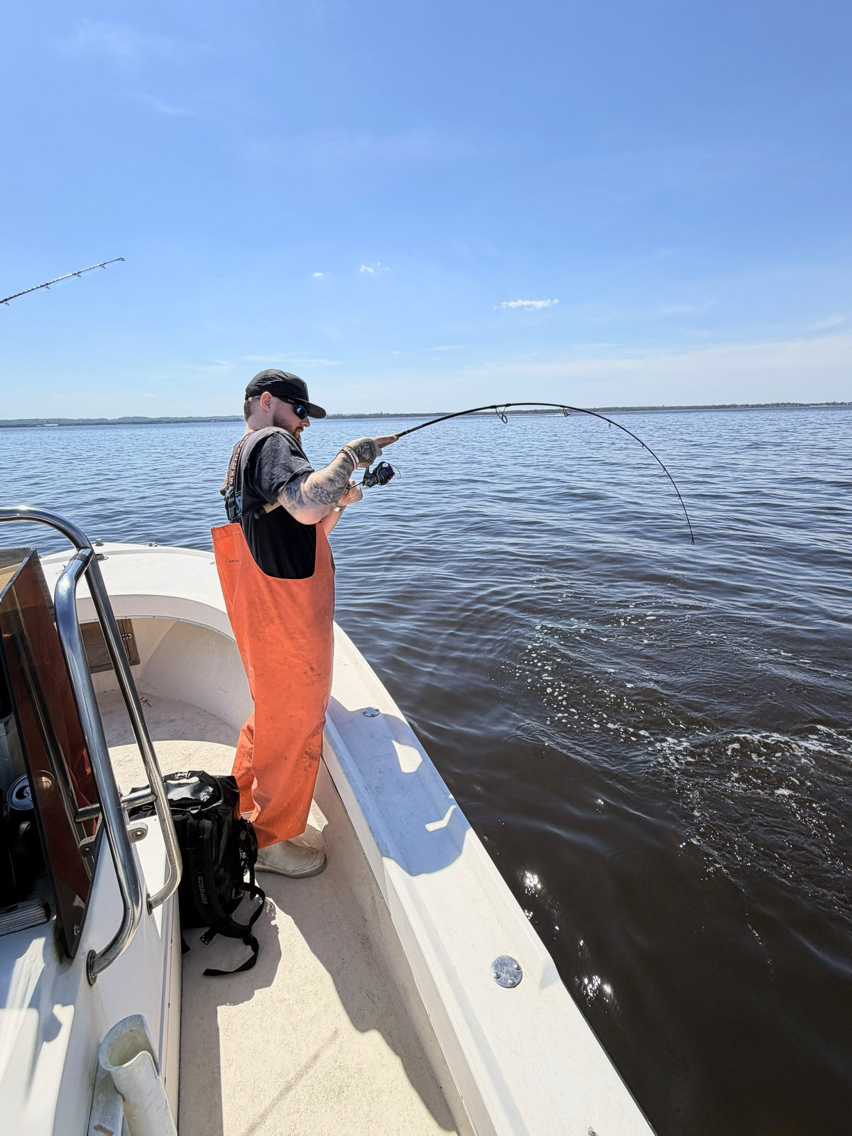 Inshore Reaper rod bent on a fish, angler in orange bibs