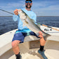 Angler with a striped bass caught on an Inshore Reaper spinning rod