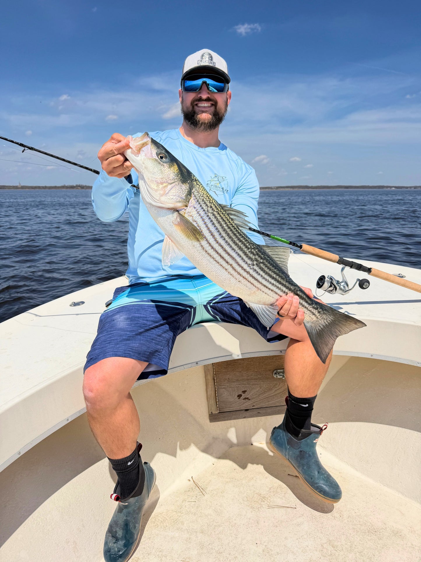 Angler with a striped bass caught on an Inshore Reaper spinning rod