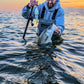 Releasing a striped bass at sunset with an Inshore Reaper rod