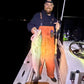Angler in orange bibs with a striped bass and Inshore Reaper rod at night