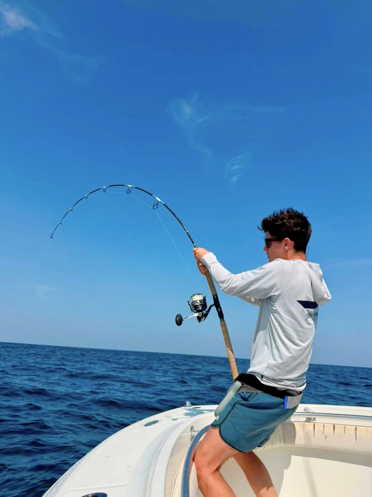 Angler leaning into a bent Pelagic Sniper spinning rod