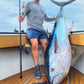 Angler on deck with a yellowfin tuna and Pelagic Sniper rod