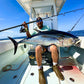 Angler with a yellowfin tuna across his lap and a Pelagic Sniper topwater rod