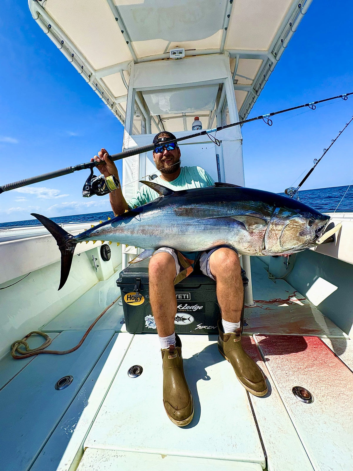 Angler with a yellowfin tuna across his lap and a Pelagic Sniper topwater rod