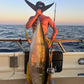 Angler with a yellowfin tuna and Phantom Jigger rod at sunset