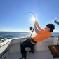 Angler leaning back into a Phantom Jigger rod, sun behind