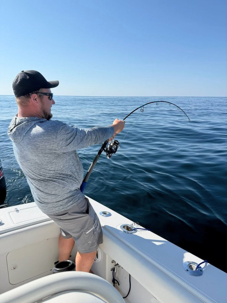 Phantom Jigger rod bent on a fish, angler at the rail