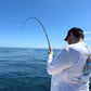 Reef Ripper rod bent on a fish over blue water