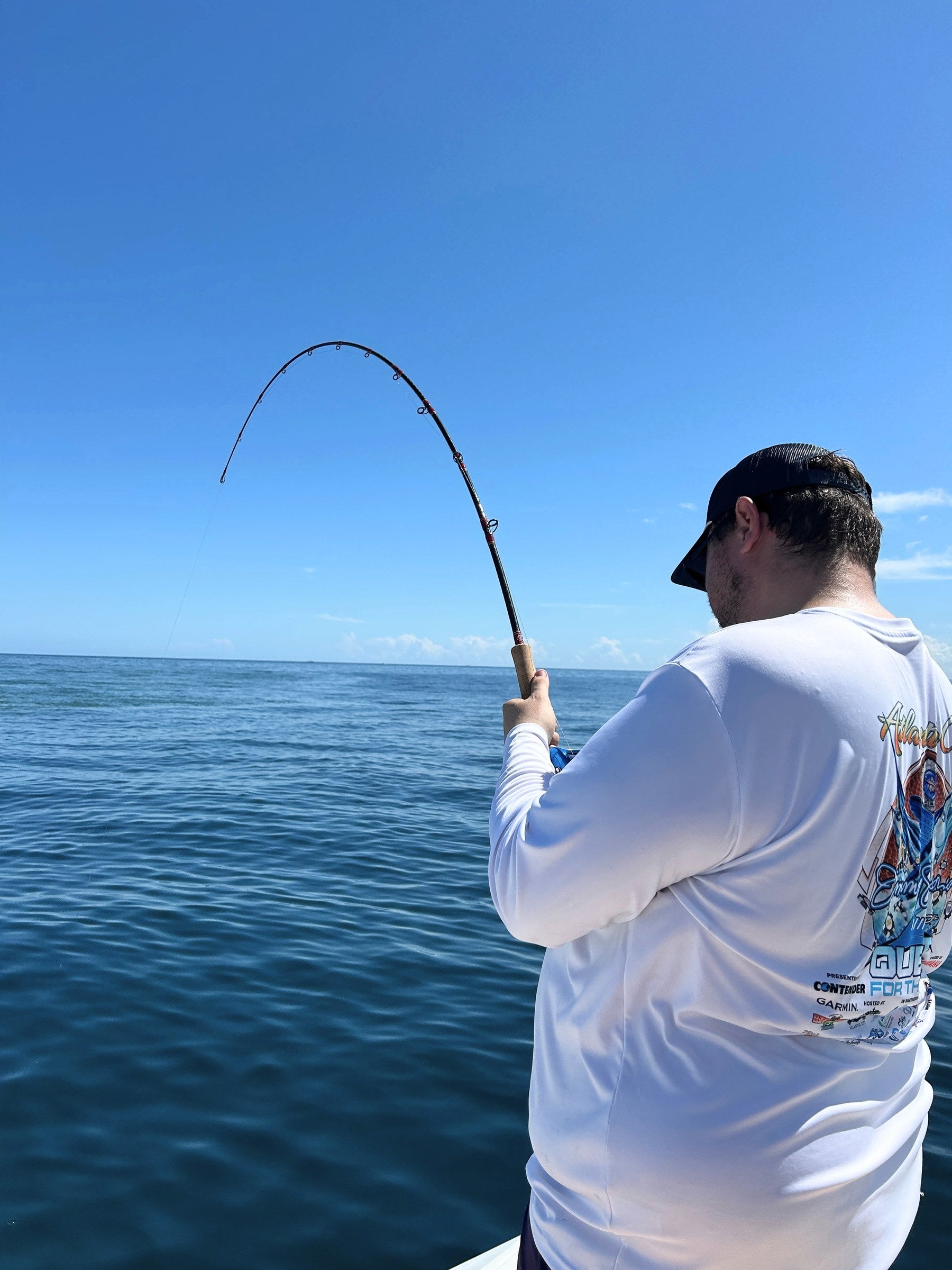 Reef Ripper rod bent on a fish over blue water