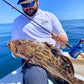 Angler with a grouper caught on a Reef Ripper conventional rod