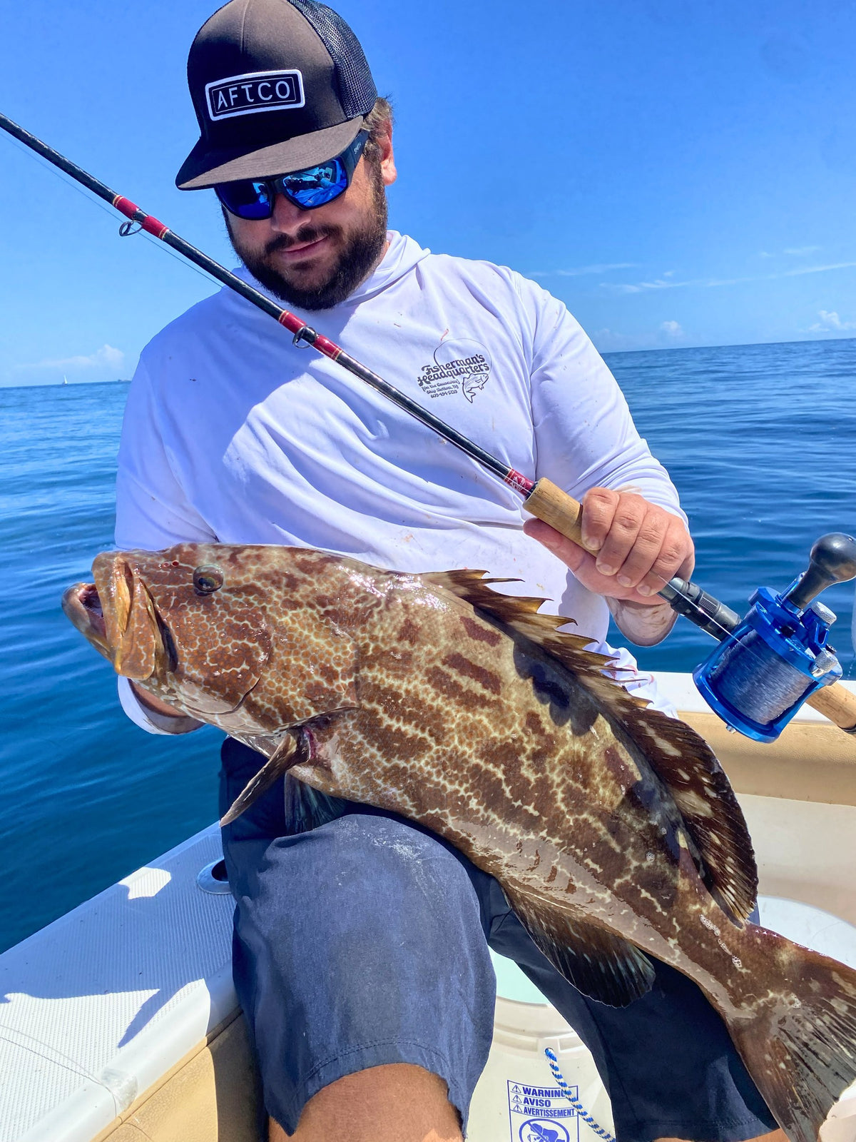 Angler with a grouper caught on a Reef Ripper conventional rod