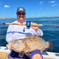 Angler holding a grouper and a Reef Ripper rod
