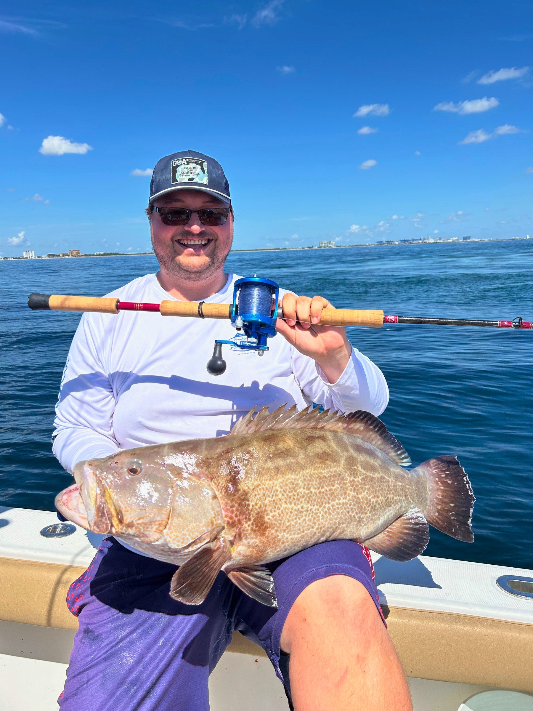 Angler holding a grouper and a Reef Ripper rod