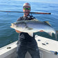 Angler with a striped bass and Tiderunner rod