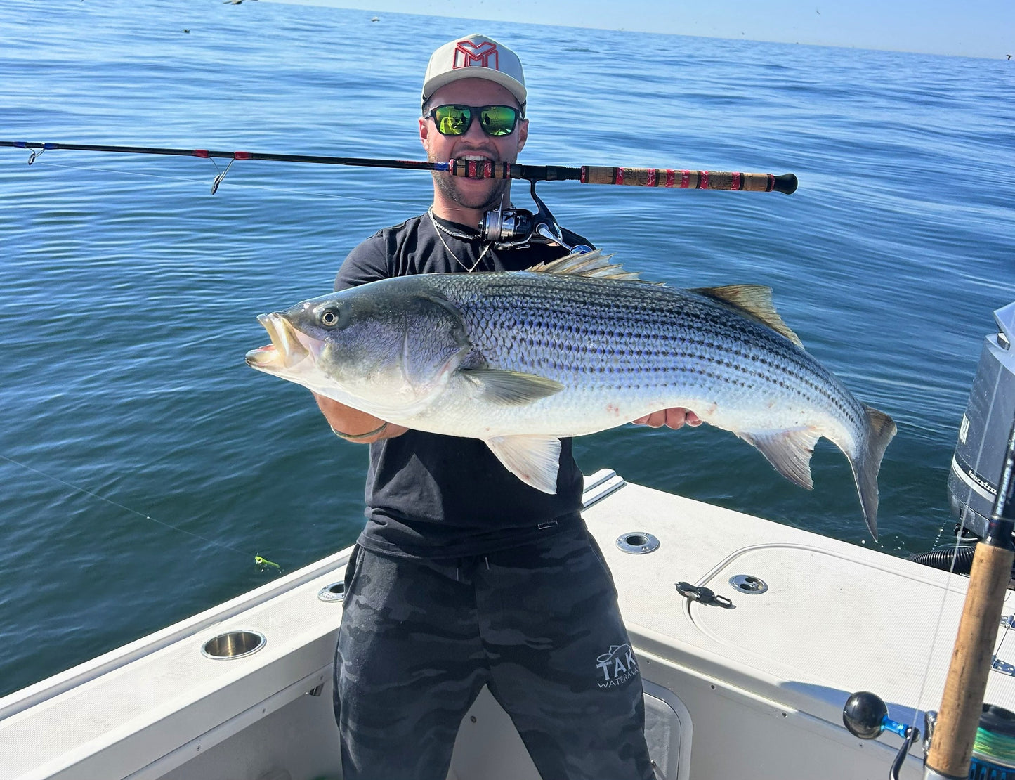 Angler with a striped bass and Tiderunner rod