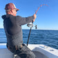 Angler with a Vert Giant jigging rod bent, conventional reel