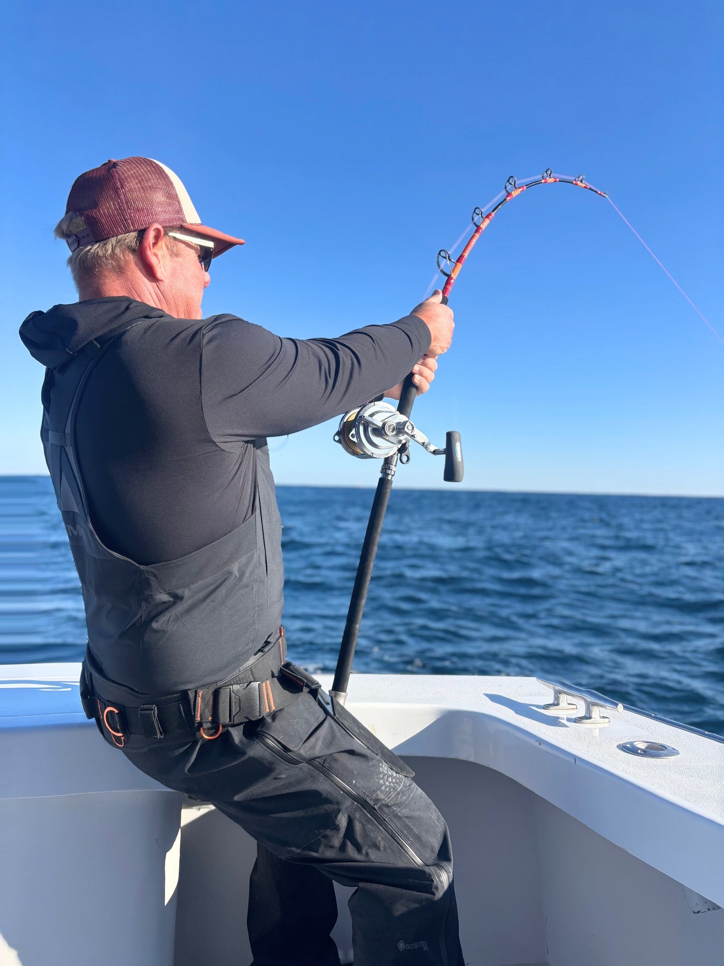 Angler with a Vert Giant jigging rod bent, conventional reel