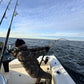 Angler in camo fighting a fish on a Vert Giant jigging rod