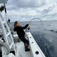 Vert Giant topwater rod bent on a fish, overcast sky